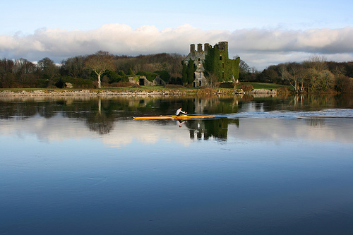 Sculler glides past Menlo Castle - the presence of any person in this photograph does not imply any type of sexual orientation